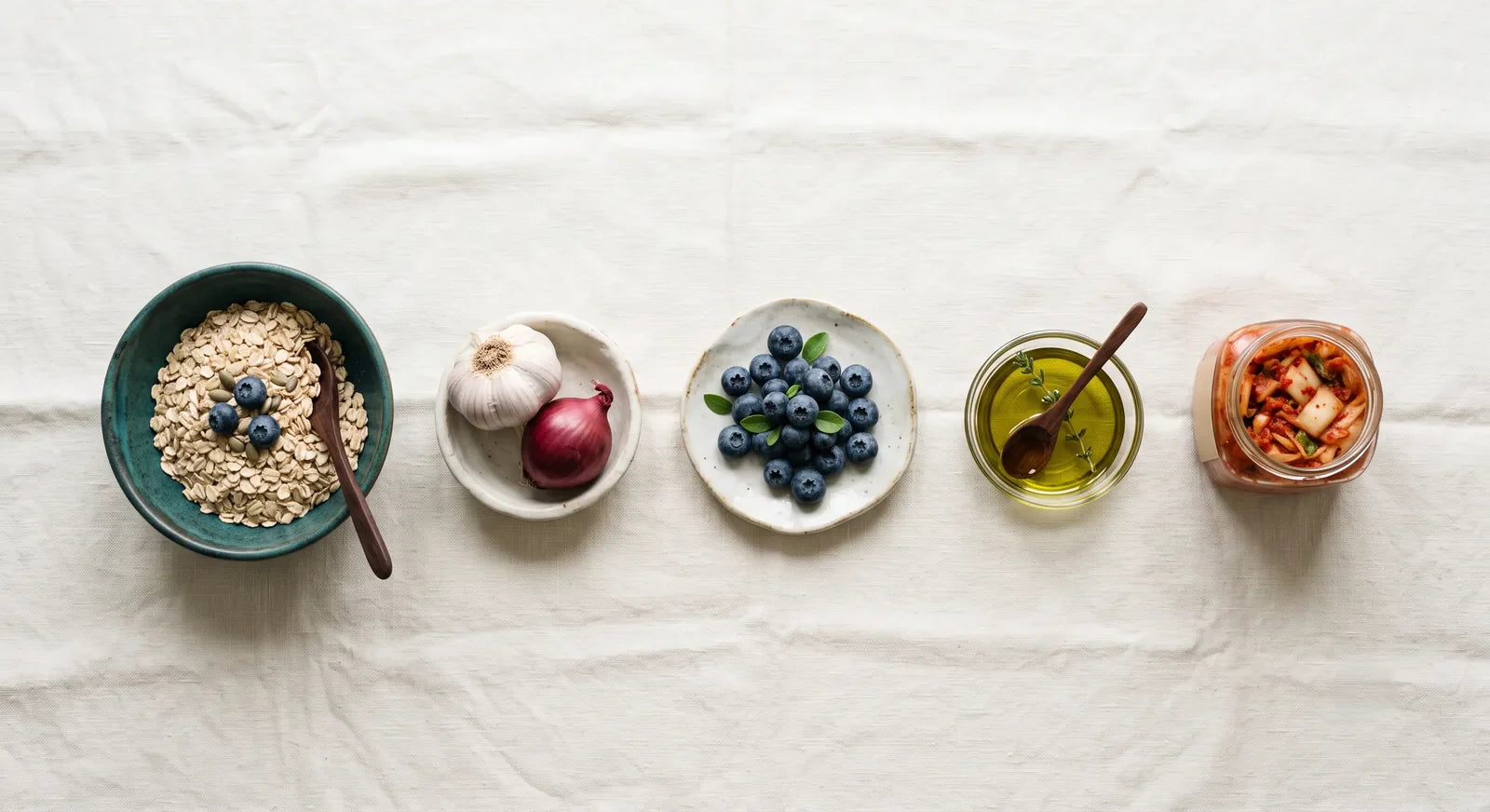 Cinco alimentos base para el intestino en fila: avena, ajo y cebolla, arándanos, aceite de oliva y kimchi